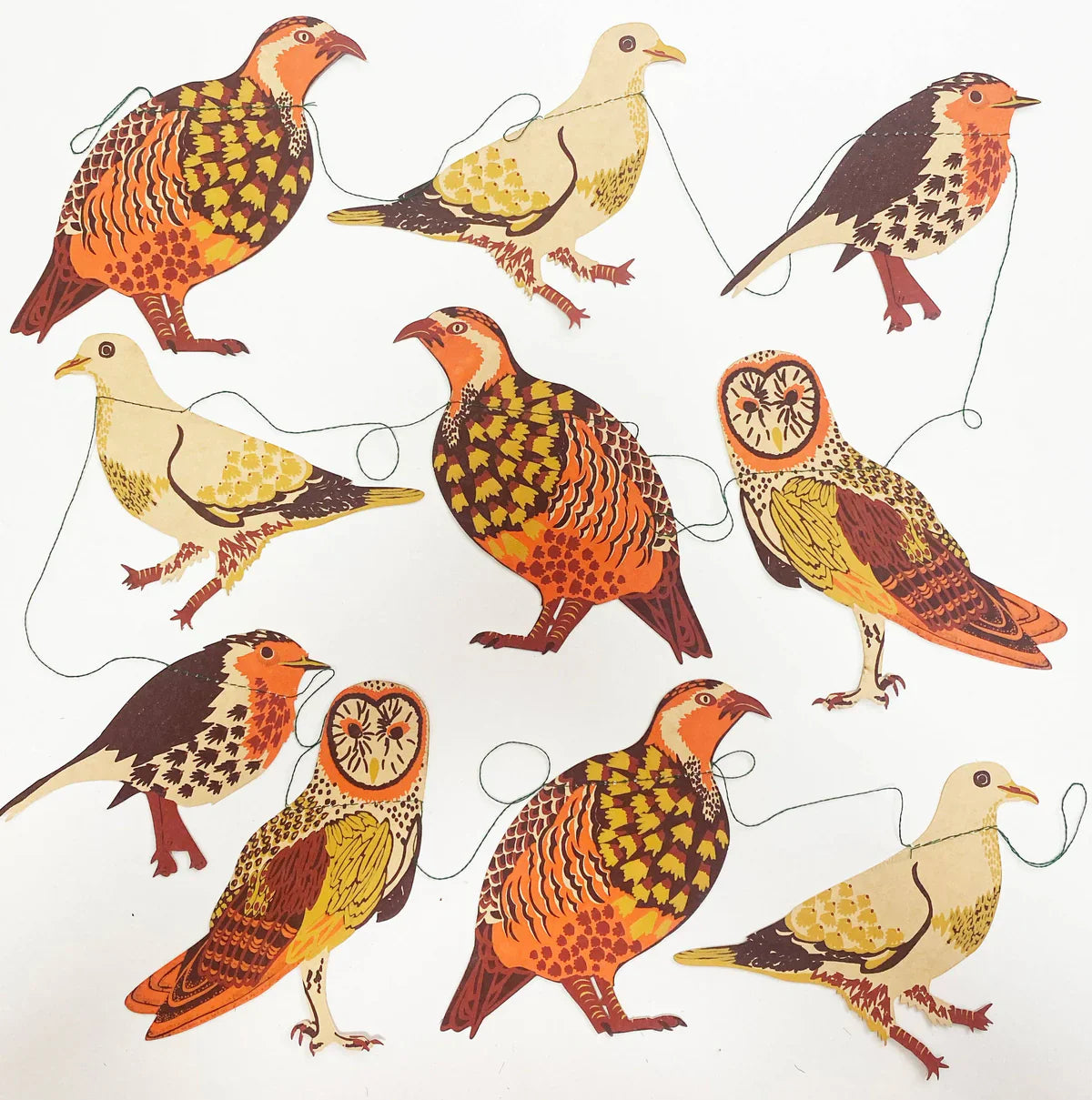 A selection of paper birds on a garland in orange, yellows, beige and brown.