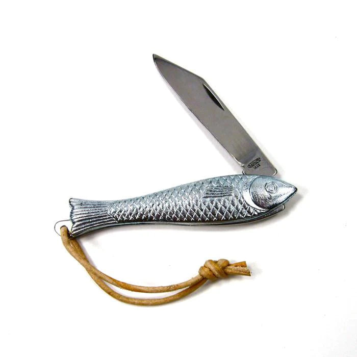 The Mollyjogger Fingerling Fish Knife (18+) is a fish-shaped metal fishing knife that features a textured handle and a stainless blade, attached to a leather rope looped cord.